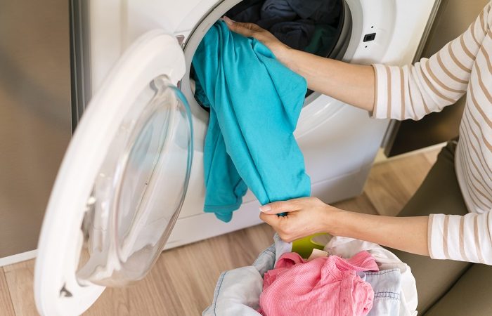 Mulher lavando roupa em uma lavanderia pequena